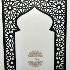 Mihrab islamique en bois noir avec motifs géométriques complexes et arc en ogive, sur fond blanc